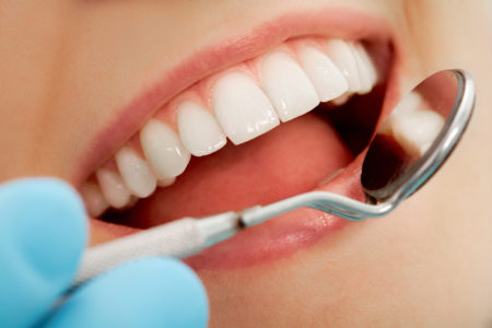 Tandlæge kigger på hvide tænder